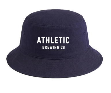 Navy blue bucket hat with white embroidered text reading ‘Athletic Brewing Co.’ on the front. The hat is shown against a light gray background.