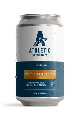 12 fl oz can of Athletic Brewing Pilot Program Mexican-Style Golden non-alcoholic brew with a clean white and navy label accented by a gold nameplate. The can is covered in condensation droplets and features the Athletic Brewing logo, “Pilot Program” branding, and product details including “Less Than 0.5% Alc/Vol.” The can is photographed against a black background, highlighting the limited-release beer packaging.